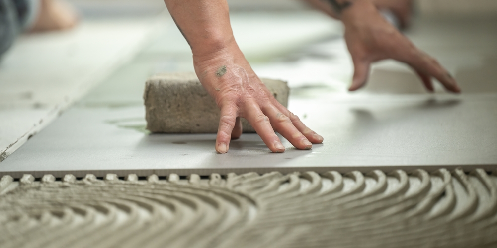 Tile being placed over freshly spread mortar