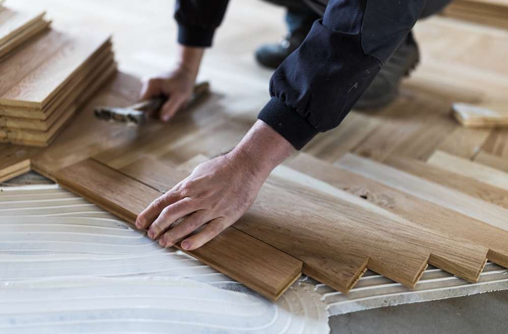Installer securing wood-look flooring planks
