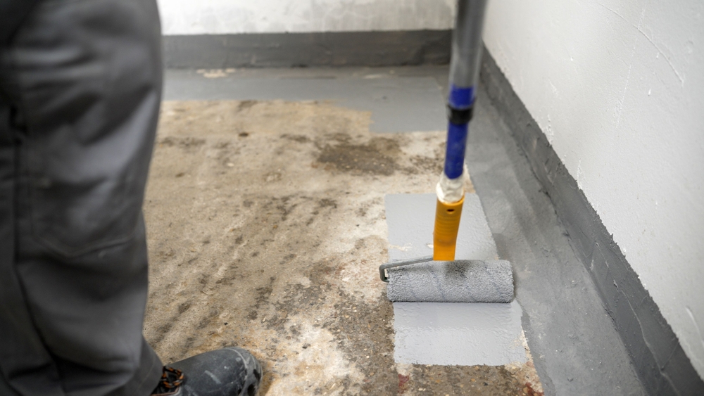Roller applying a coating to a prepared subfloor
